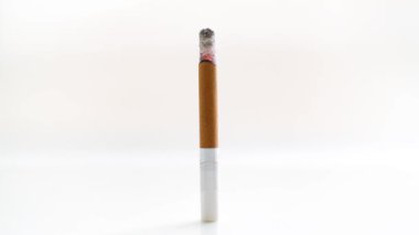 Zaman ayarlı 4K video sigara yakma, sigara içme ve parlak bir arka plan karşısında küle dönüşme