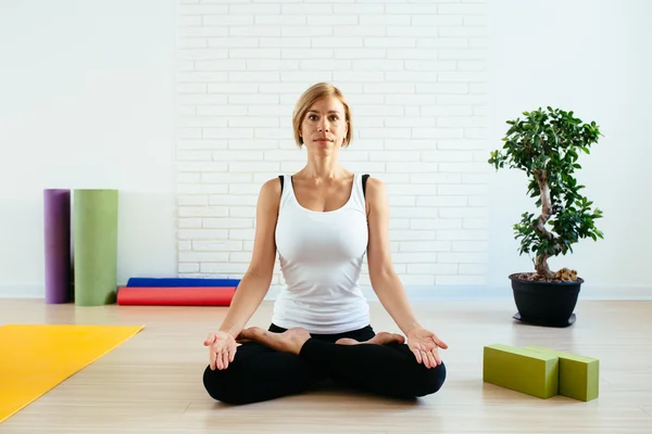 woman doing yoga in studio lotus position