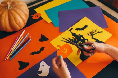 eller arka plan Cadılar Bayramı kompozisyon kağıt kabak kesme makası ile kapatın. Castle, hayaletler, kabak ve diğer el yapımı ürkütücü süslemeleri