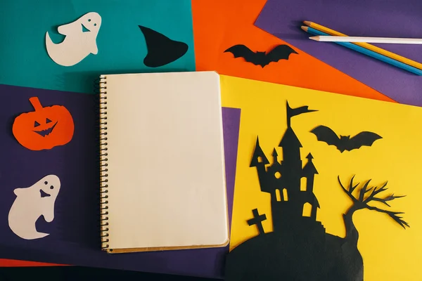 Portátiles en blanco página en el fondo composición de Halloween. cuaderno y decoraciones de papel hechas a mano para Halloween — Foto de Stock