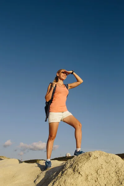 3.年轻女子徒步旅行者背着背包站在山顶上，高瞻远瞩 — 图库照片
