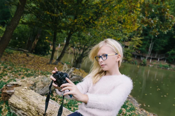 Blondes Mädchen mit Brille fotografierte sich vor laufender Kamera im Freien. Mädchen macht Selfie vor Kamera im Park — Stockfoto