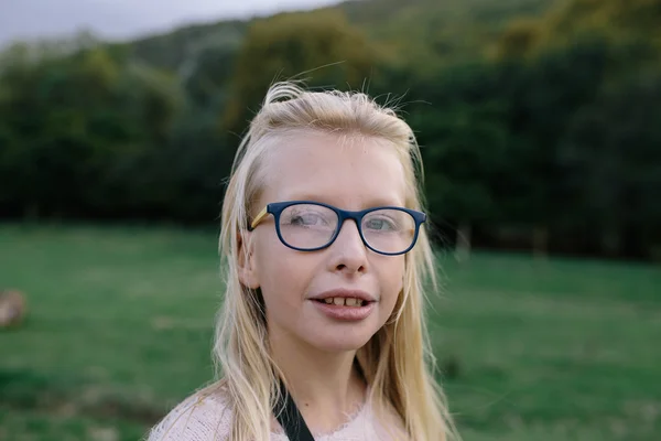 Porträtt av en blond tjej med glasögon utomhus i parken — Stockfoto