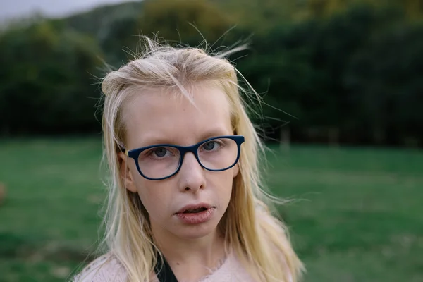 Portrait d'une fille blonde triste avec des lunettes à l'extérieur dans le parc — Photo