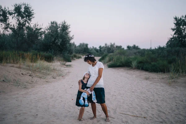 Kvinnan kramar sin lilla blonda dotter — Stockfoto