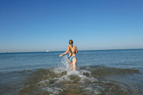Femme pénètre dans l'eau de mer — Photo