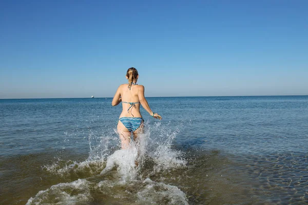 Femme pénètre dans l'eau de mer — Photo