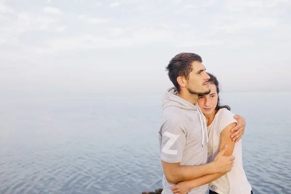 Jovens abraços de casal junto ao mar . — Fotografia de Stock