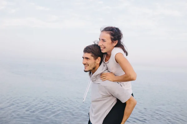 Jovem casal abraços e se diverte — Fotografia de Stock