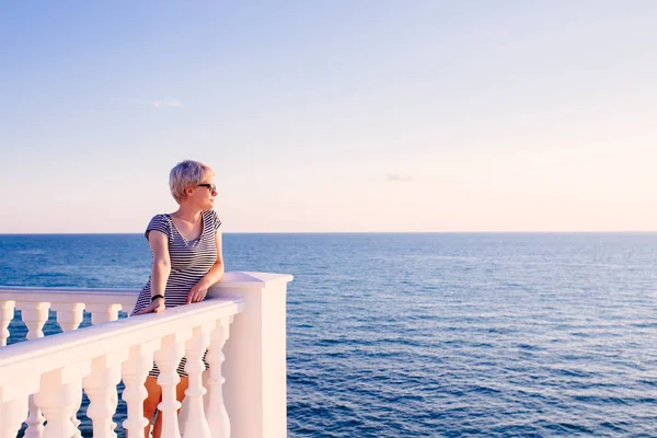 Femme sur le balcon regardant l'océan — Photo