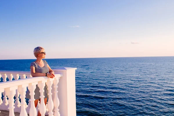 Kobieta na balkon widokiem na ocean — Zdjęcie stockowe
