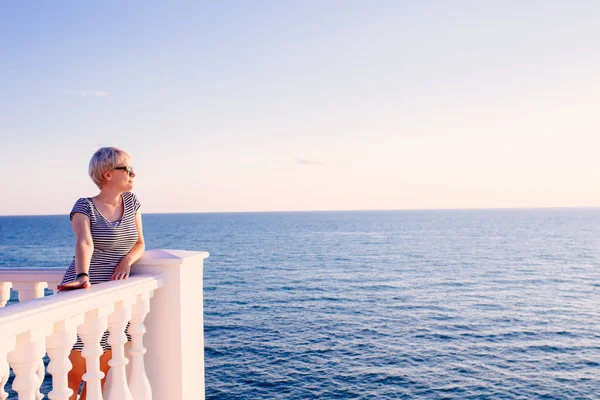 Femme sur le balcon regardant l'océan — Photo