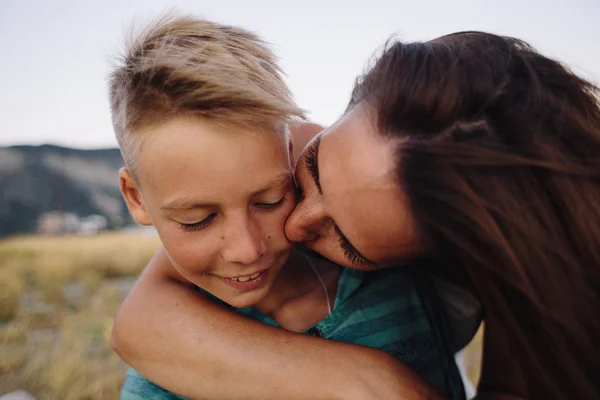 Mulher beijando seu filho sorridente — Fotografia de Stock