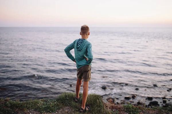 Chłopiec stoi w pobliżu morza. — Zdjęcie stockowe