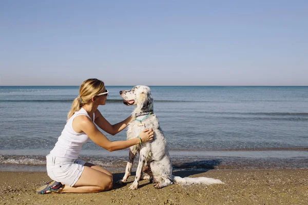 Vrouw knuffelen van een grote witte hond — Stockfoto