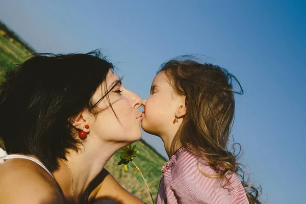 Mãe beijando sua filha — Fotografia de Stock