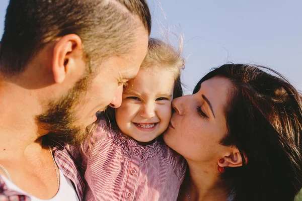 Far och mor kyssar t dotter — Stockfoto