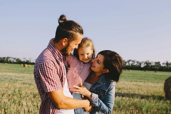 Far och mor kramar dotter — Stockfoto