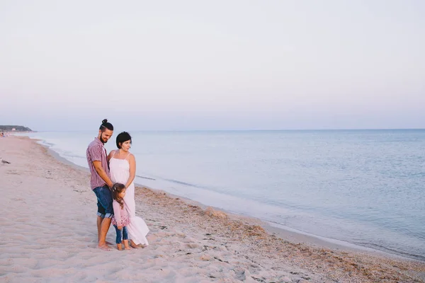 Familj med barn stående på havsstranden — Stockfoto