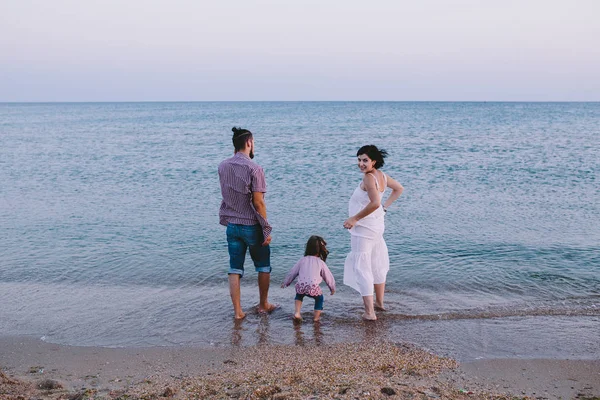 Família feliz em pé na praia — Fotografia de Stock