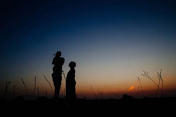 Familia feliz con un niño en un campo —  Fotos de Stock