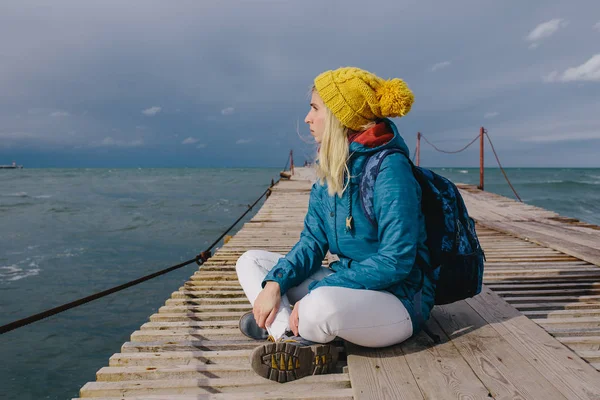 Ahşap bir iskele üzerinde oturan kadın — Stok fotoğraf