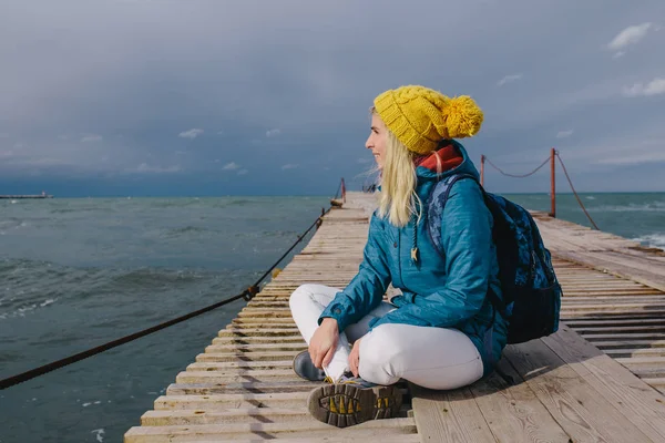 Woman sitting on a wooden pier — Stock Photo, Image