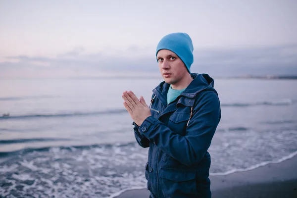 freezing young man on the beach.