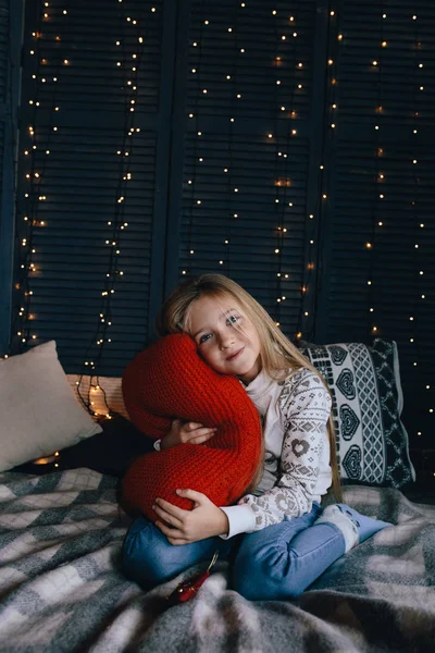 Menina em suéter sentado na cama — Fotografia de Stock