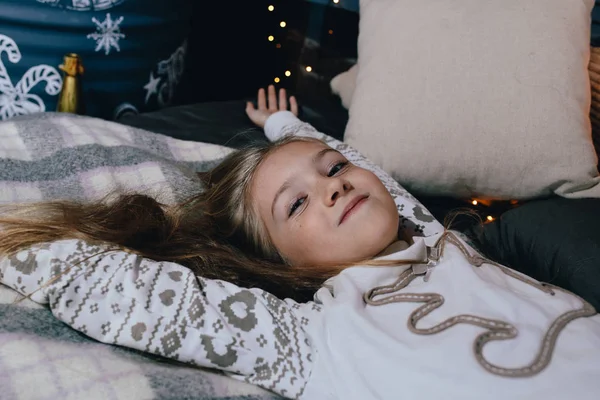 Menina bonita em suéter alongamento na cama . — Fotografia de Stock