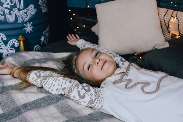 Menina bonita no pijama alongamento na cama — Fotografia de Stock