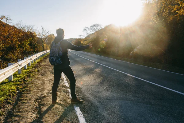 Man hitchhiking on a country road — Stock Photo, Image