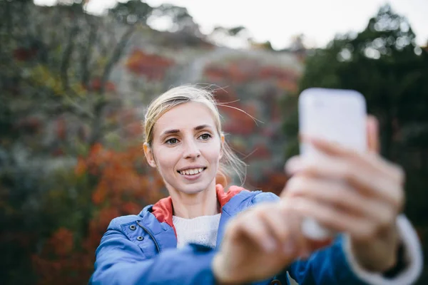 Mujer excursionista utiliza teléfono inteligente — Foto de Stock