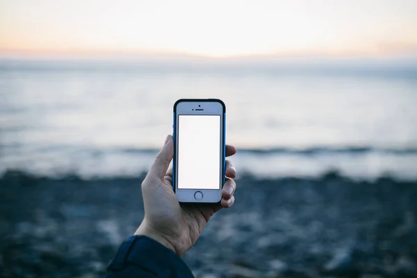 Sahilde cep telefonu kullanan adam