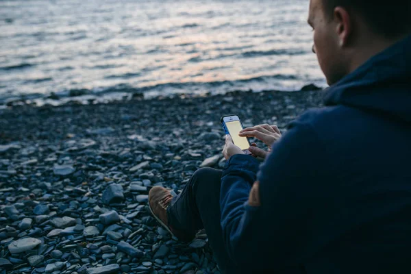 Uomo che utilizza il telefono cellulare sulla spiaggia — Foto Stock