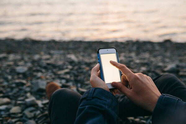 мужчина с мобильным телефоном на пляже
