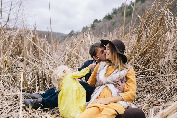 Feliz familia joven entre cañas secas . — Foto de Stock