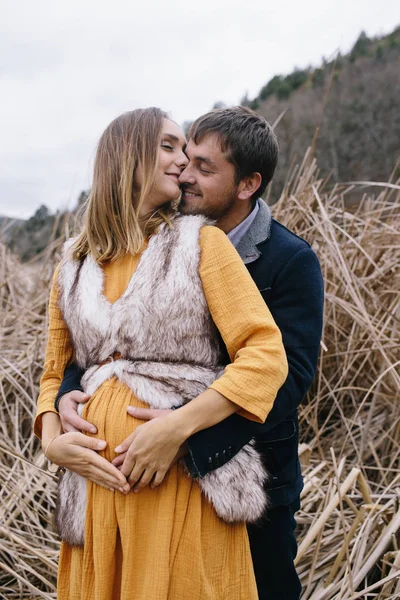 Człowieka ogarnia i całuje kobietę w ciąży — Zdjęcie stockowe
