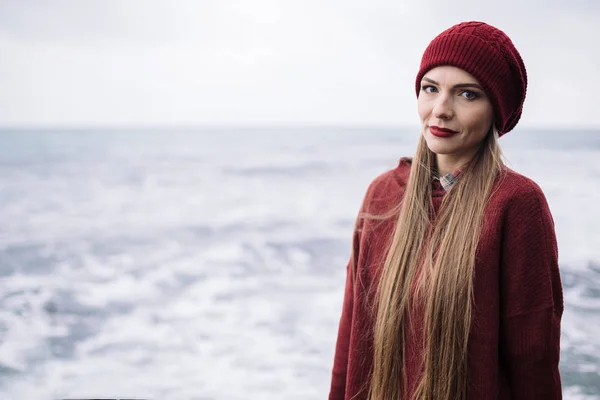 Jeune femme en chapeau et pull bordeaux — Photo