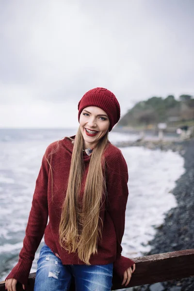 Ung kvinna i vinröd mössa och tröja — Stockfoto