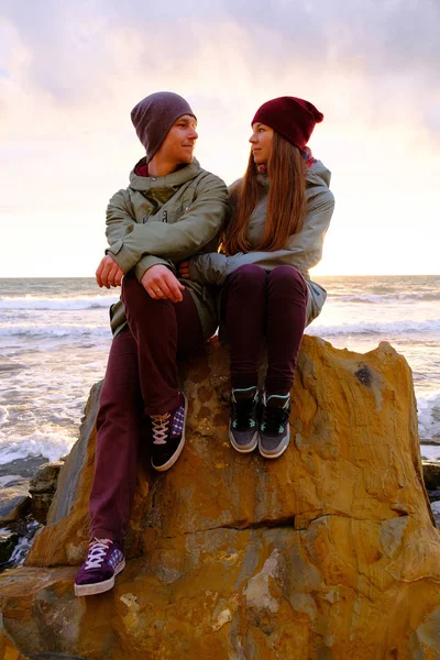 Młoda para siedzi na seashore — Zdjęcie stockowe