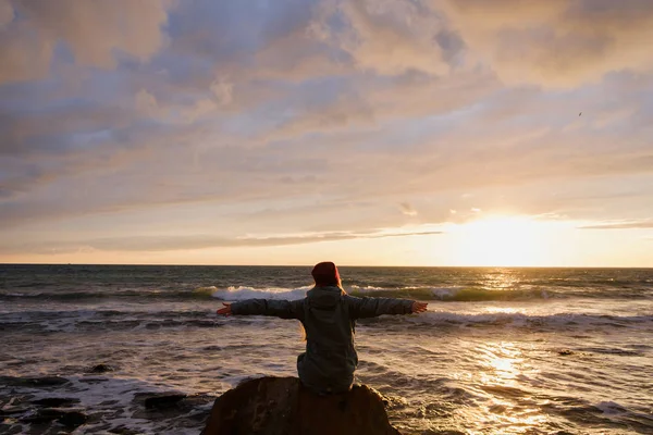 Woman sitting on rock on beach — Stock Photo, Image