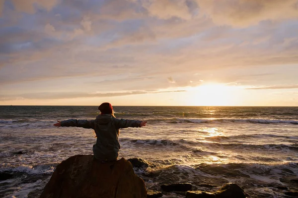 Woman sitting on rock on beach — Stock Photo, Image