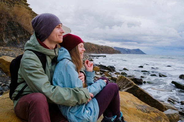 Unga paret sitter på havsstranden — Stockfoto