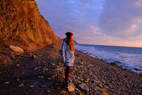 Jeune femme sur le coucher du soleil bord de mer — Photo
