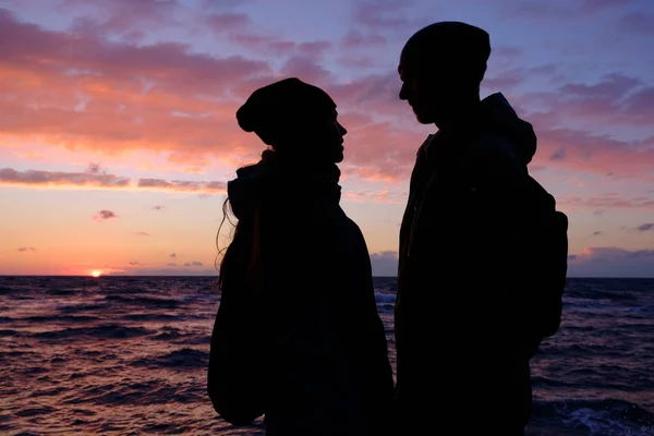 Casal com mar tempestuoso e céu por do sol — Fotografia de Stock