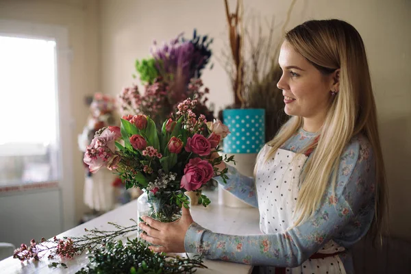 Florist göra bukett med rosor och tulpaner — Stockfoto