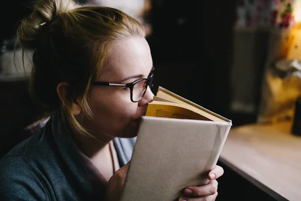 Jovem mulher cheirando livro — Fotografia de Stock
