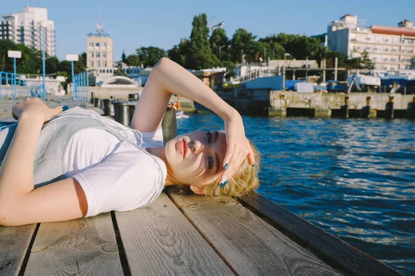 Chica adolescente mintiendo en muelle — Foto de Stock