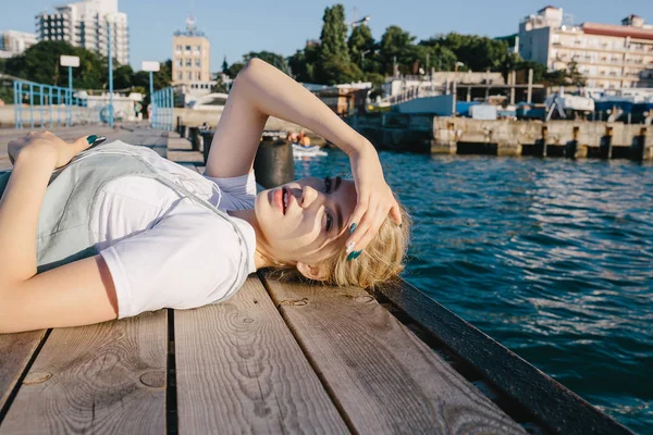 Chica adolescente mintiendo en muelle — Foto de Stock